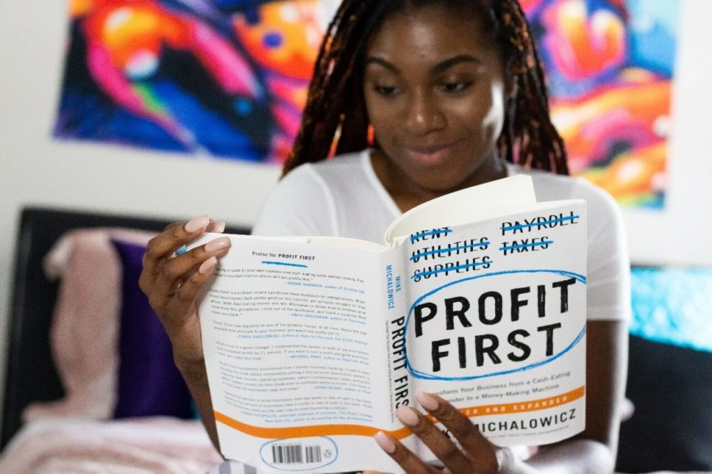 triple-e-training-the-positive-impacts-of-abet-young-african-woman-reading-book-about-profit